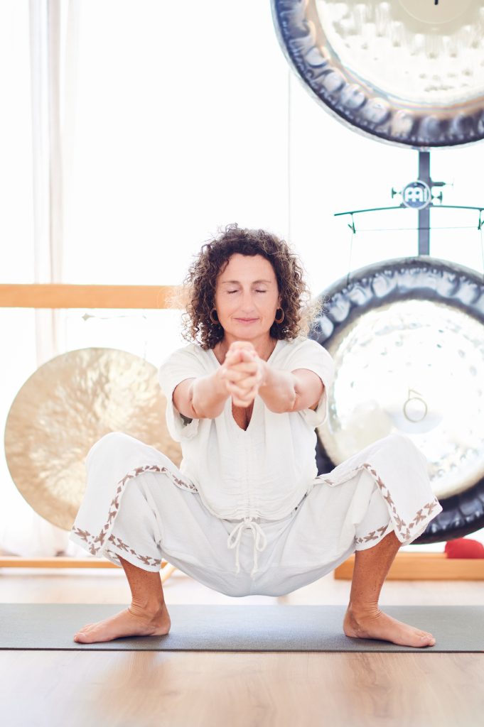 manuela haciendo una àsana de espaldas a los gongs, en Ram yoga